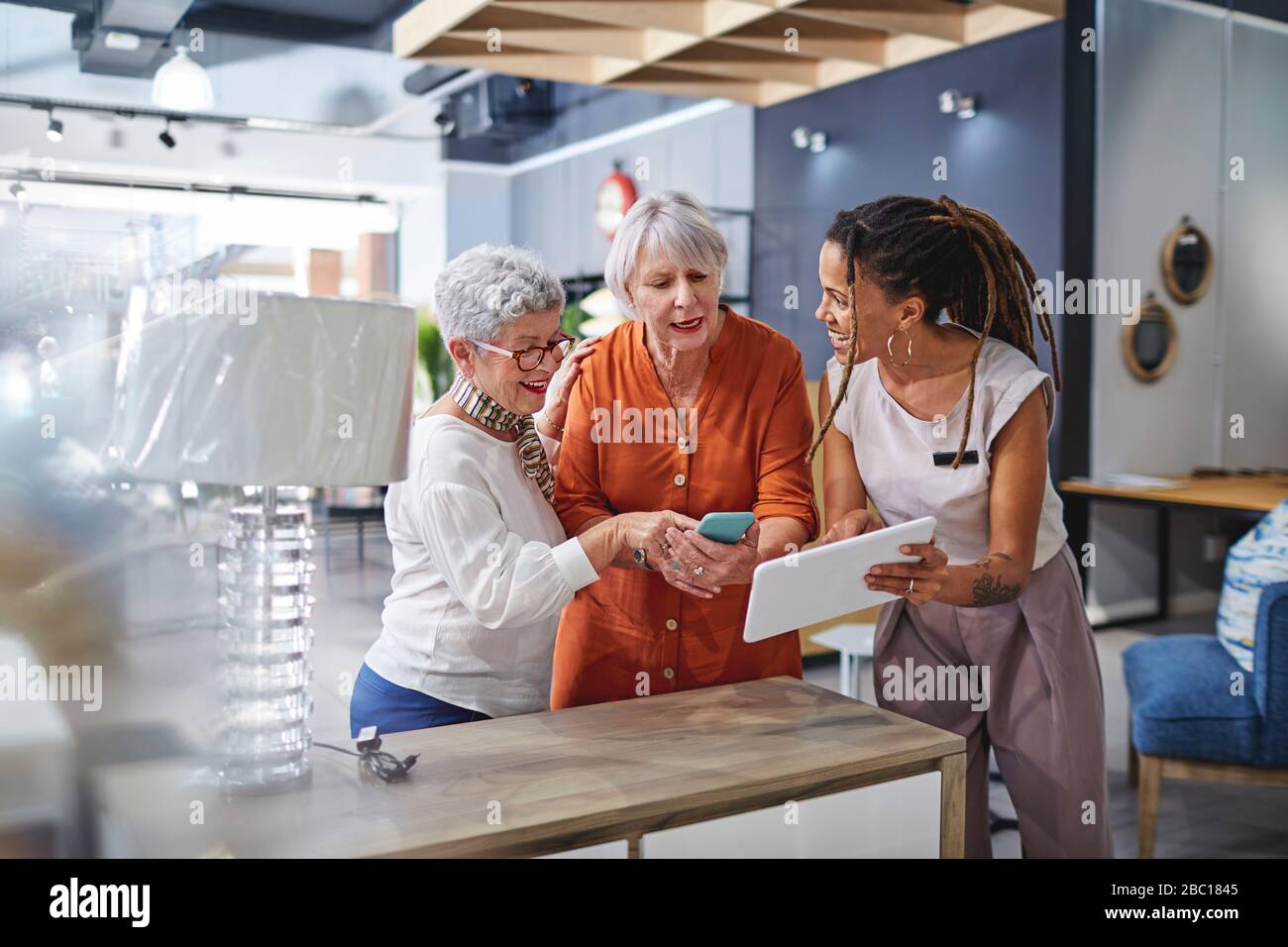 Femme aidant les clients à faire du shopping dans un magasin de décoration Banque D'Images