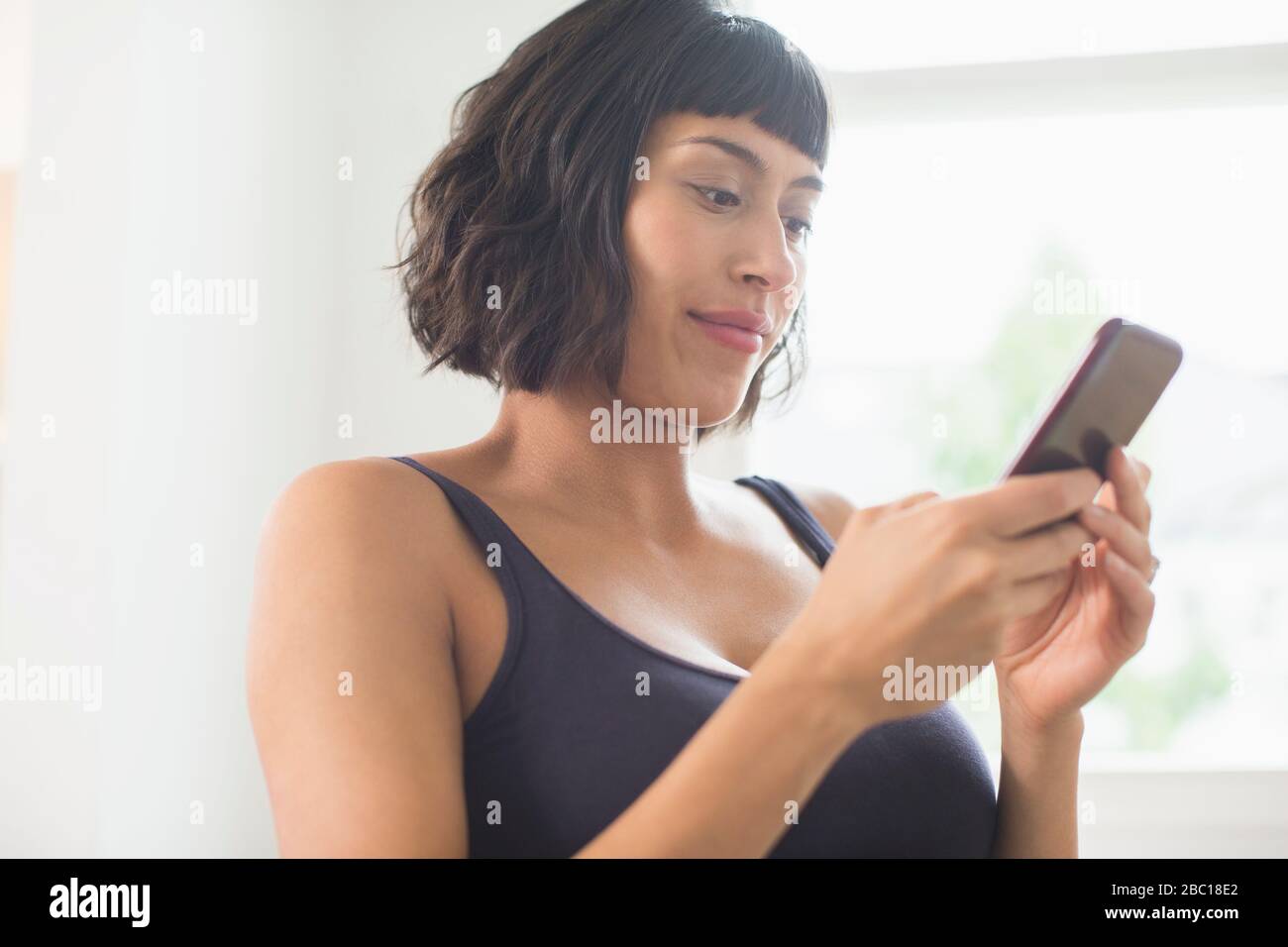 Femme en soutien-gorge à l'aide d'un smartphone Banque D'Images