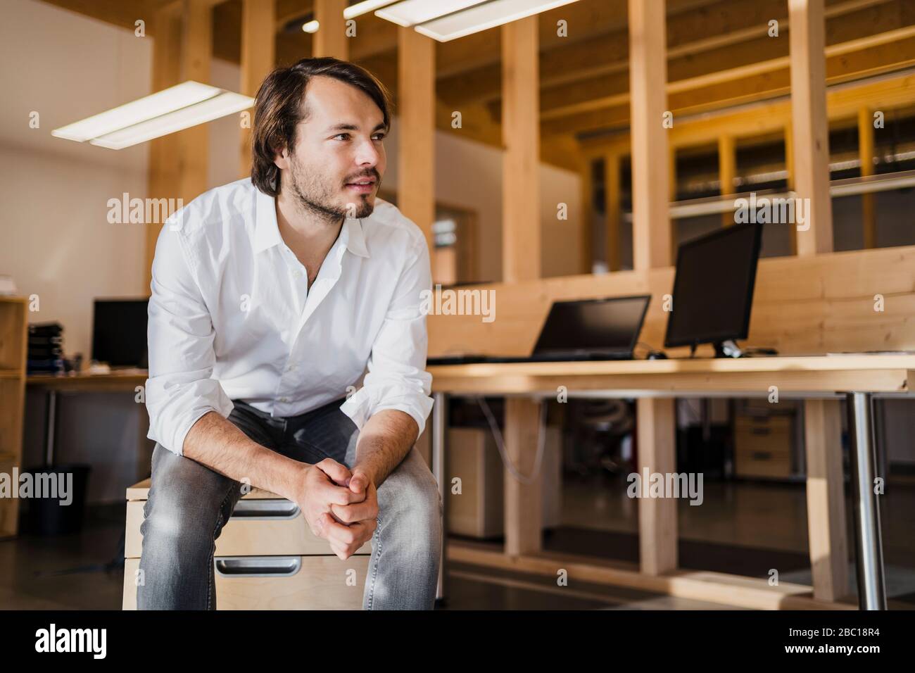 Portrait d'un homme d'affaires confiant dans un bureau en bois à plan ouvert Banque D'Images