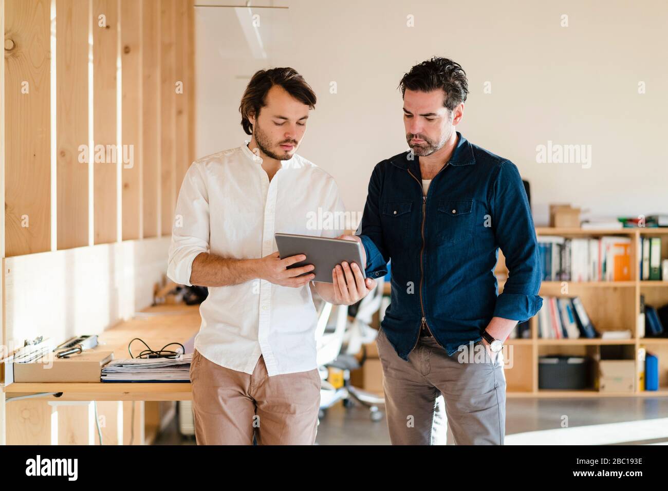Deux hommes d'affaires avec tablette en bois à plan ouvert bureau Banque D'Images