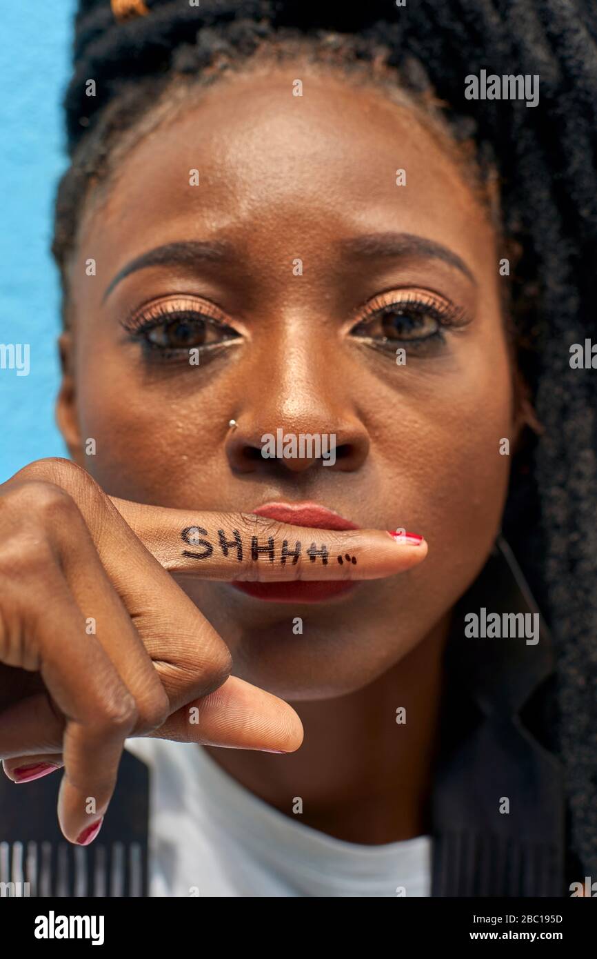 Portrait de la femme faisant le signe du silence avec son doigt et un message Shhhh sur lui Banque D'Images