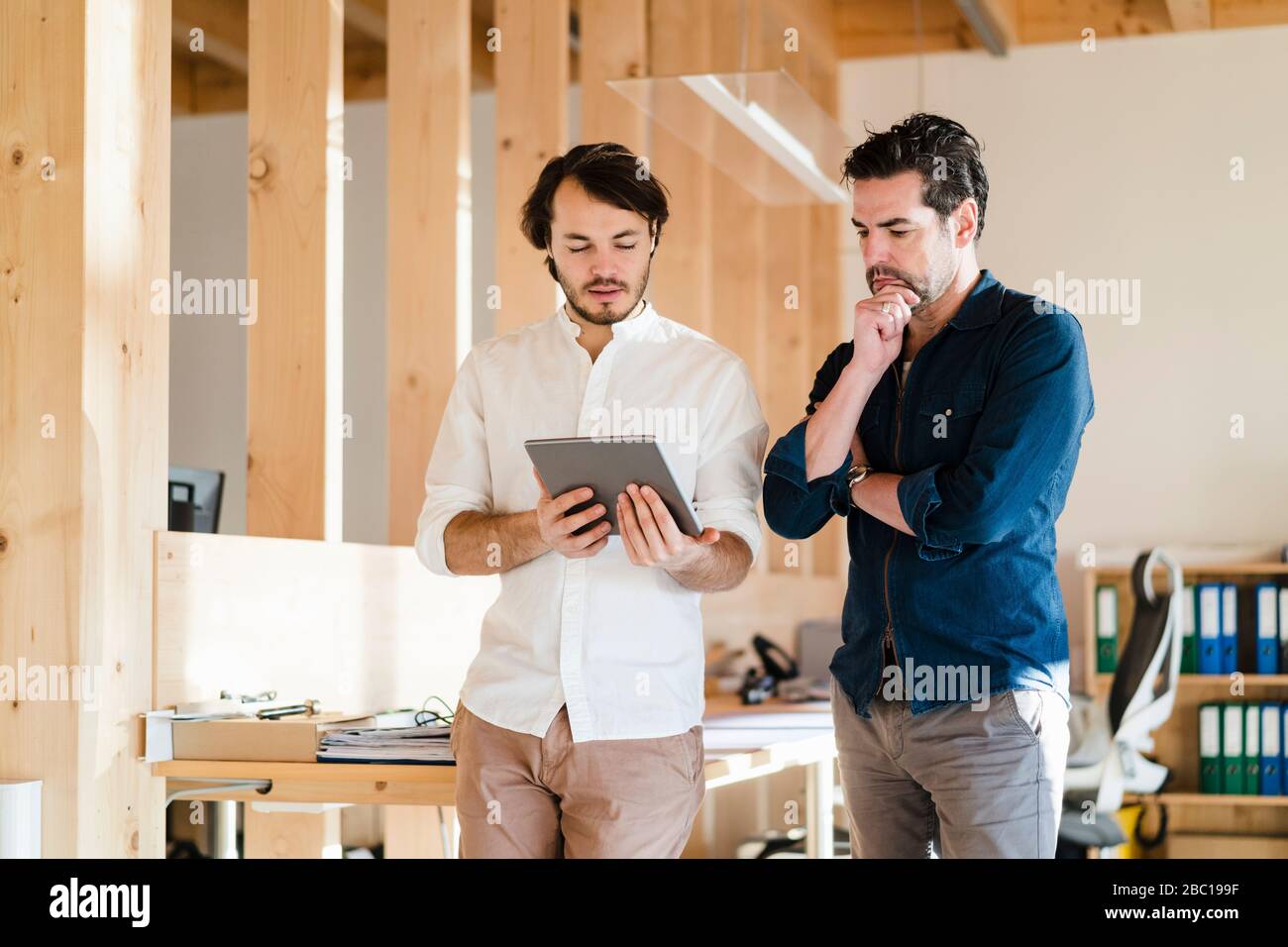 Deux hommes d'affaires avec tablette en bois à plan ouvert bureau Banque D'Images