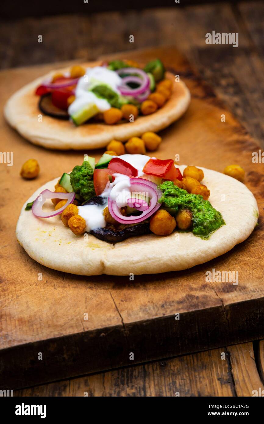 Sabich israélien avec pain pita, aubergine, pois chiches, tomates, concombre, yaourt et sauce zhoug Banque D'Images