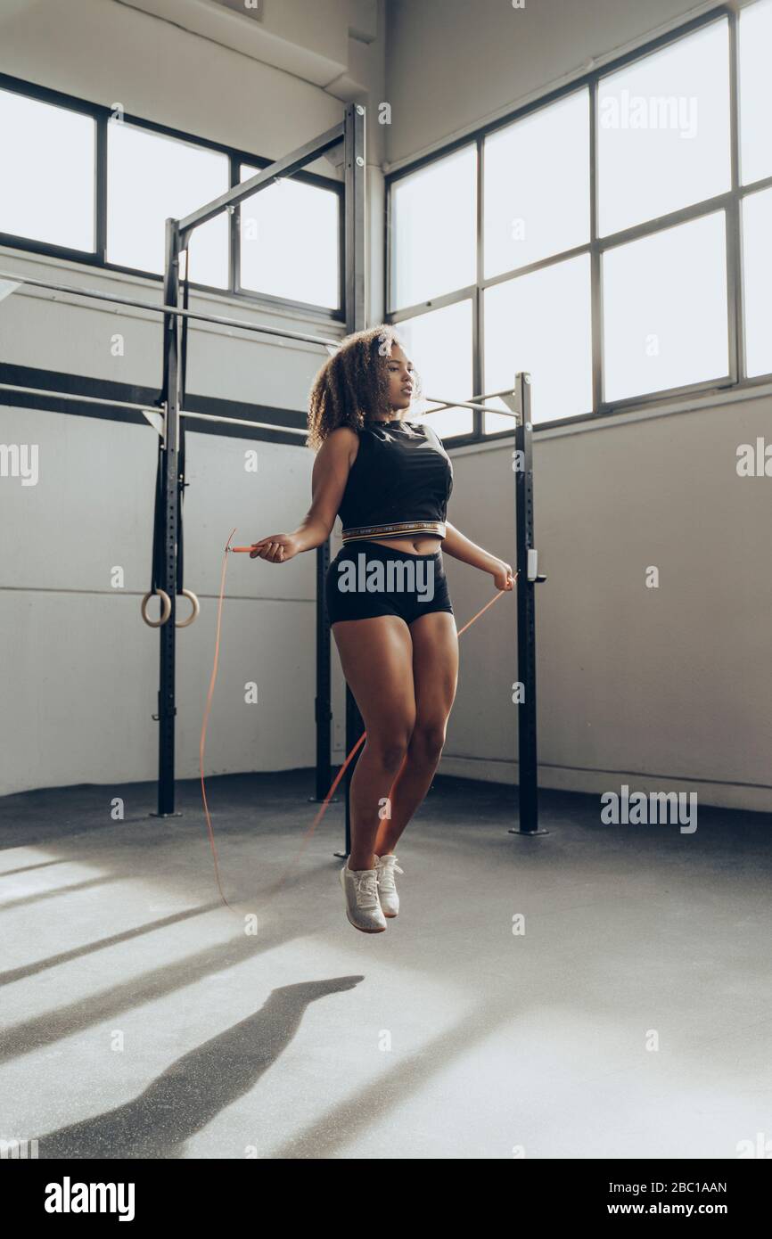 Jeune femme sautant la corde dans la salle de gym Banque D'Images
