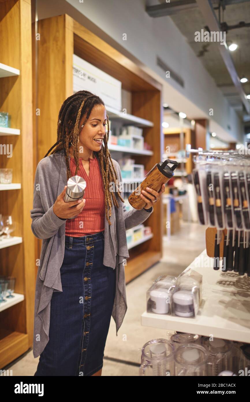 Femme faisant des achats pour des récipients de boisson isolés dans un magasin de produits ménagers Banque D'Images