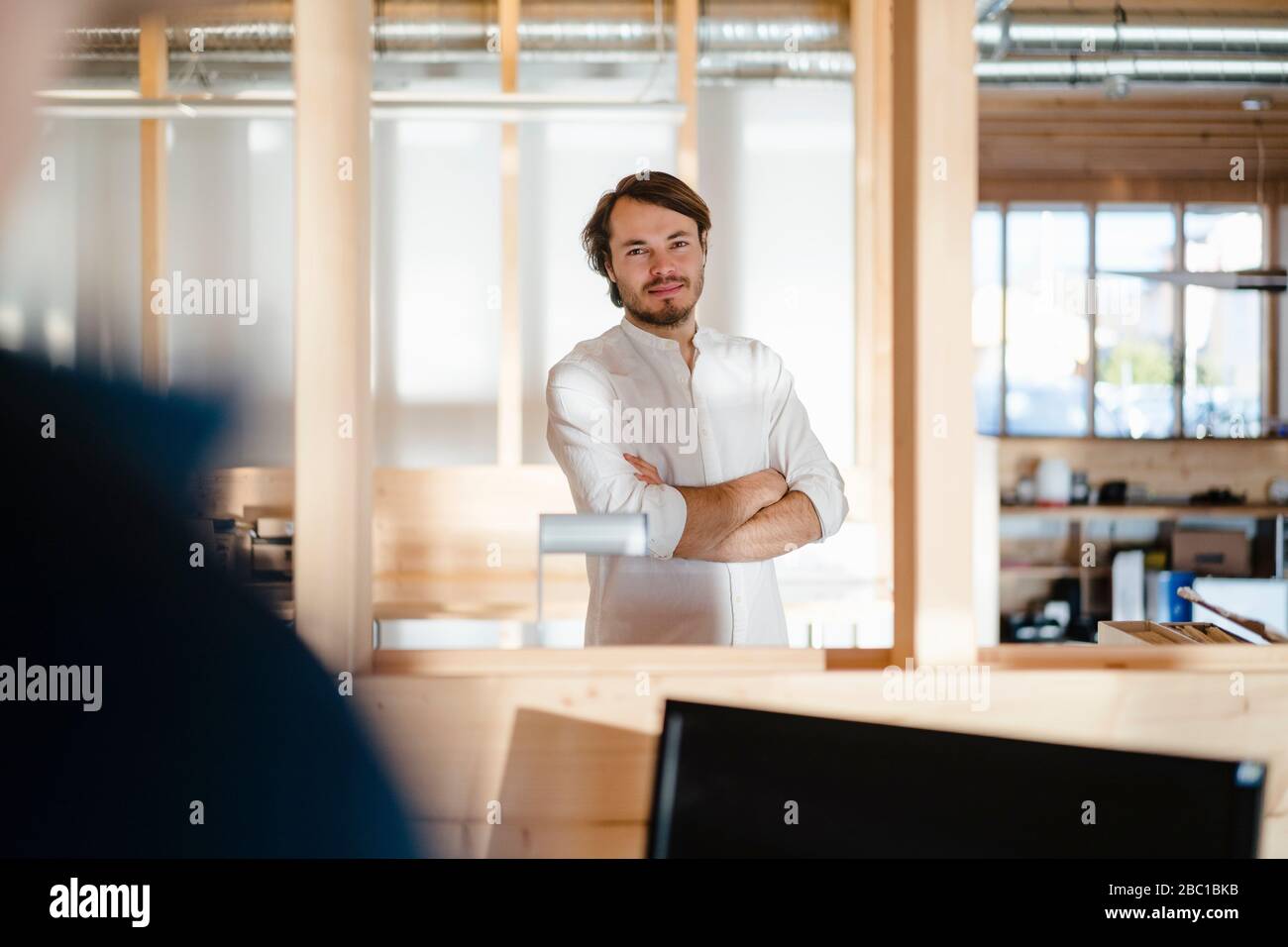Portrait d'un homme d'affaires confiant dans un bureau en bois à plan ouvert Banque D'Images