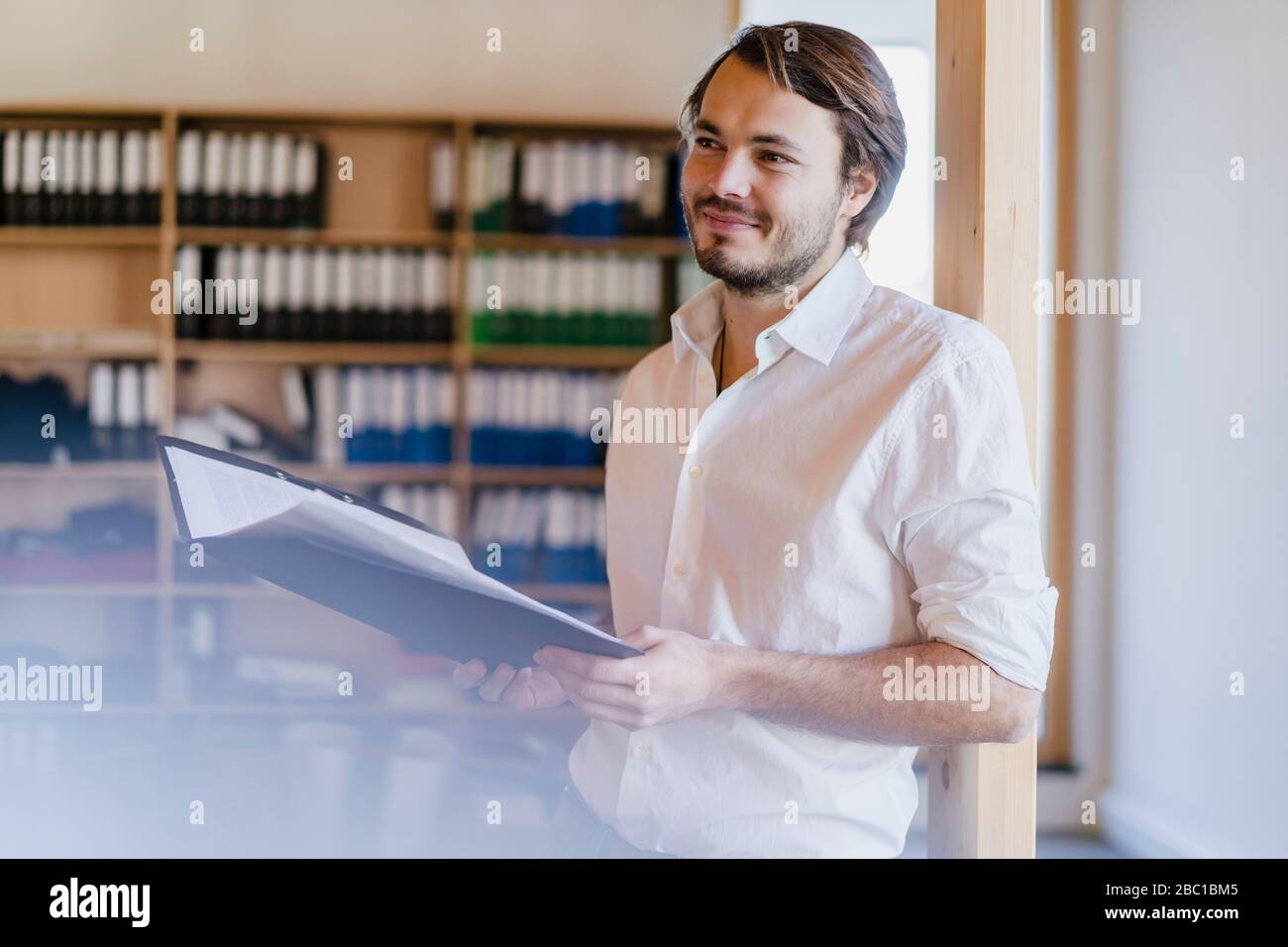 Bbusinman avec dossier dans un bureau en bois à plan ouvert Banque D'Images