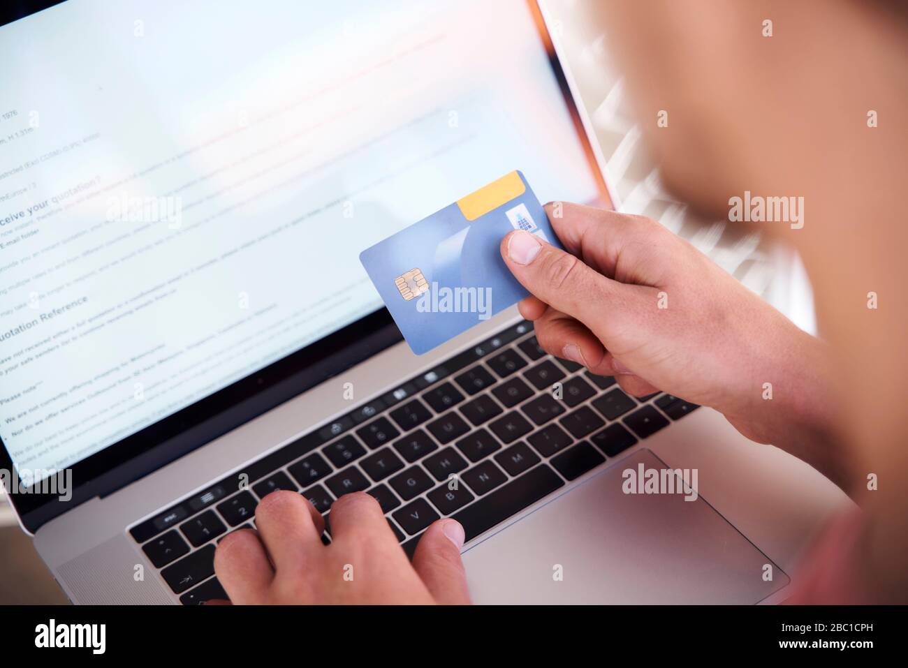 Man using laptop and holding credit card, close-up Banque D'Images