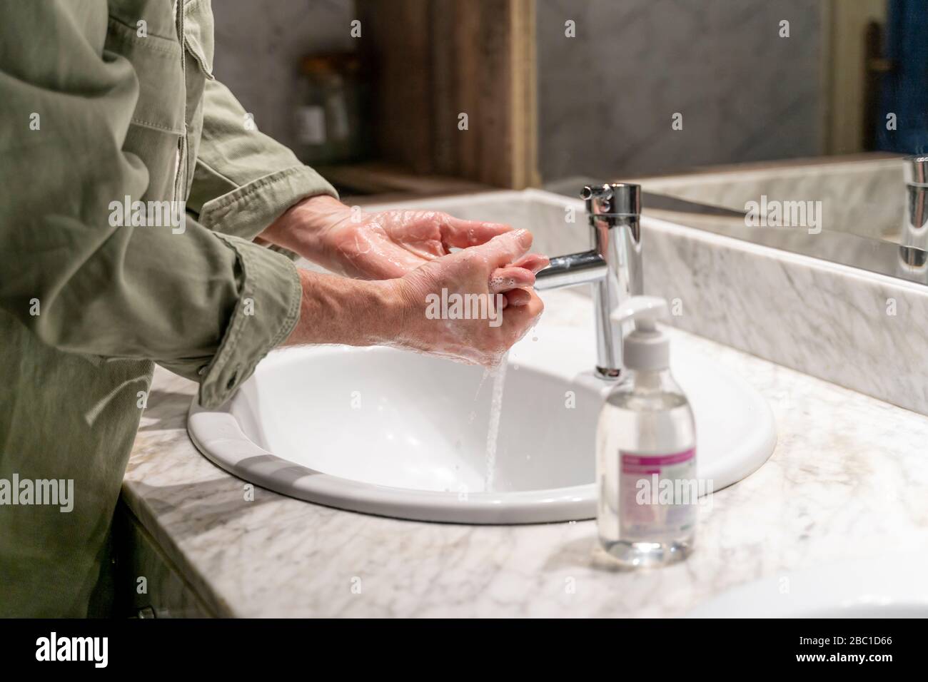 L'homme se lave les mains avec de l'aseptisant Banque D'Images
