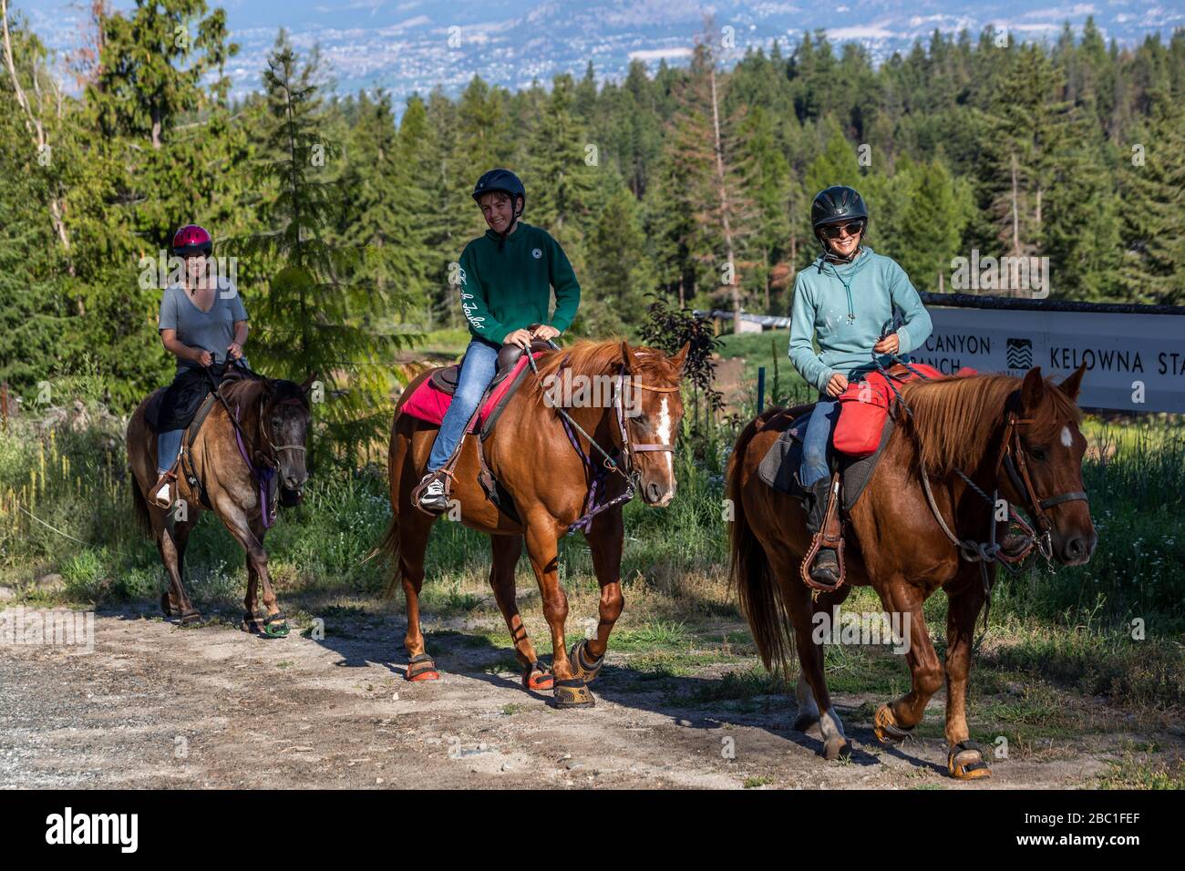 Mère et fils avec guide à l'avant des chevaux à cheval au Myra Canyon Ranch, Kelowna, C.-B., Canada. Banque D'Images