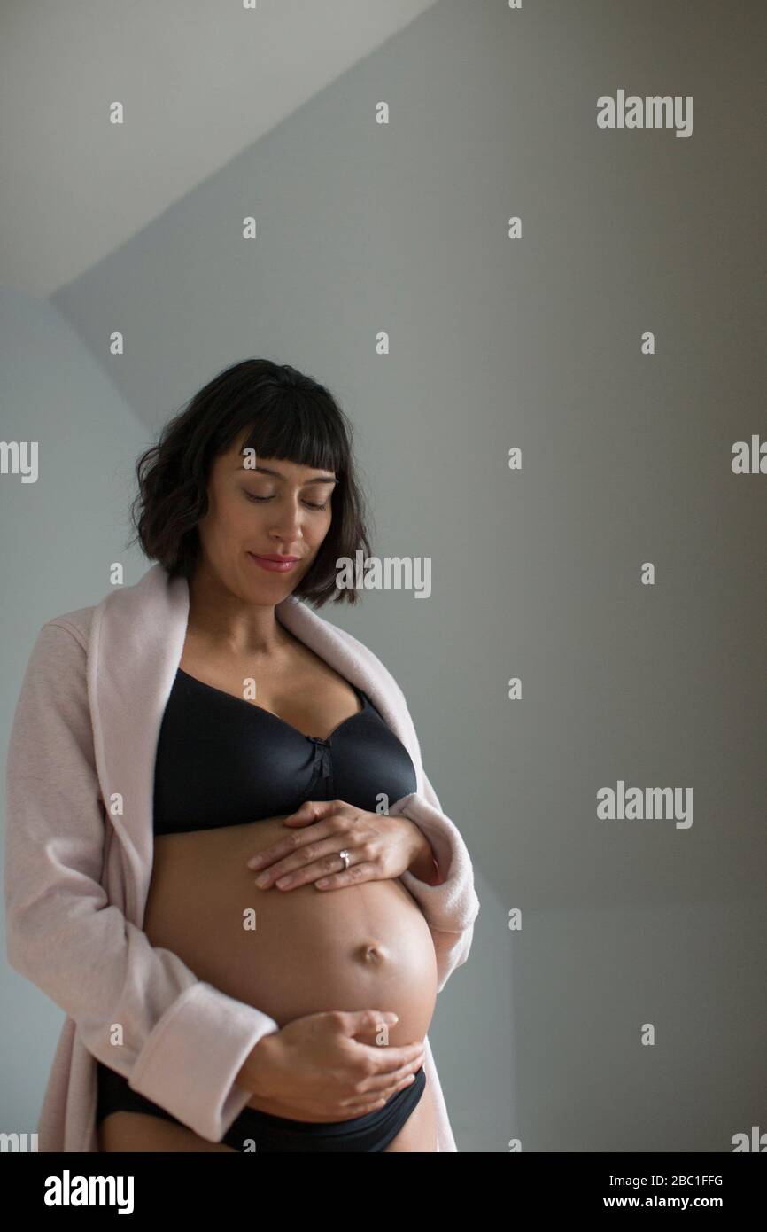 Femme enceinte dans le soutien-gorge tenant l'estomac Banque D'Images