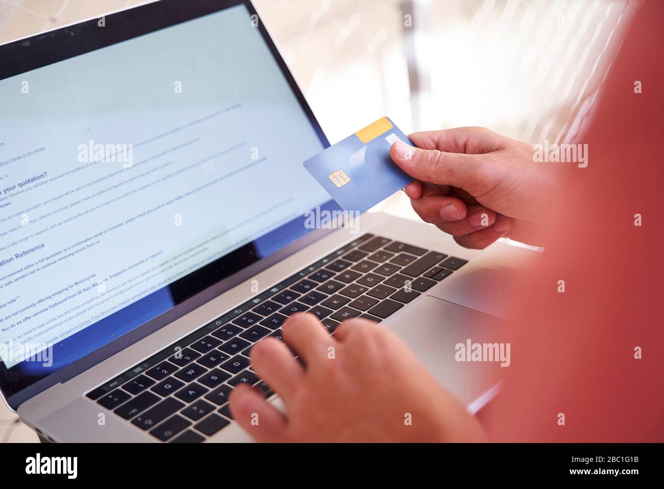 Man using laptop and holding credit card, close-up Banque D'Images
