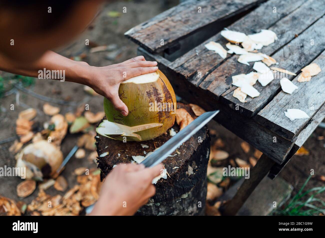 Vue sur la culture du jeune homme ouvrant la noix de coco, île Bornéo, Malaisie Banque D'Images