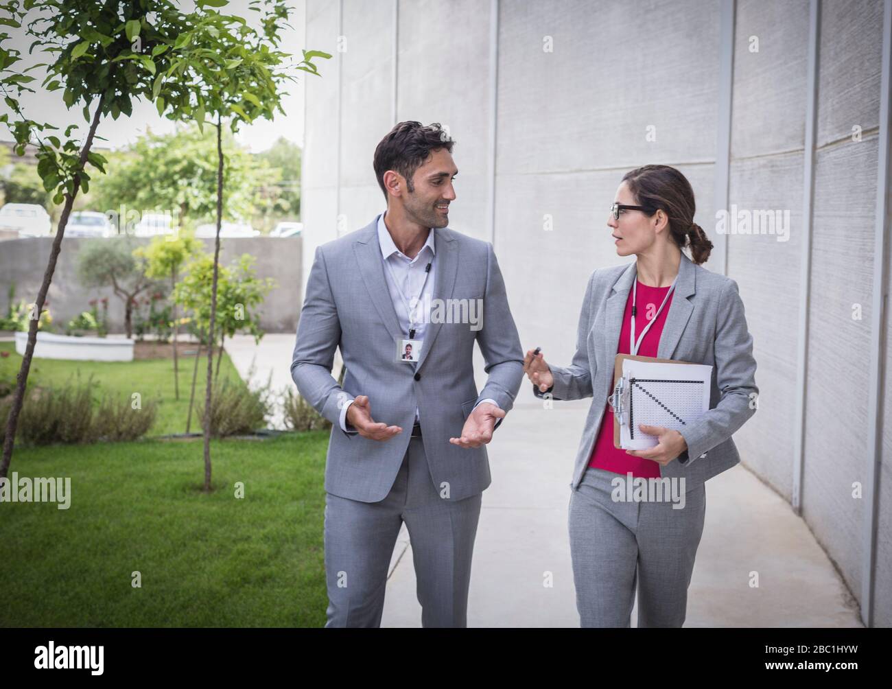 Homme d'affaires et femme d'affaires marchant et parlant sur le trottoir Banque D'Images