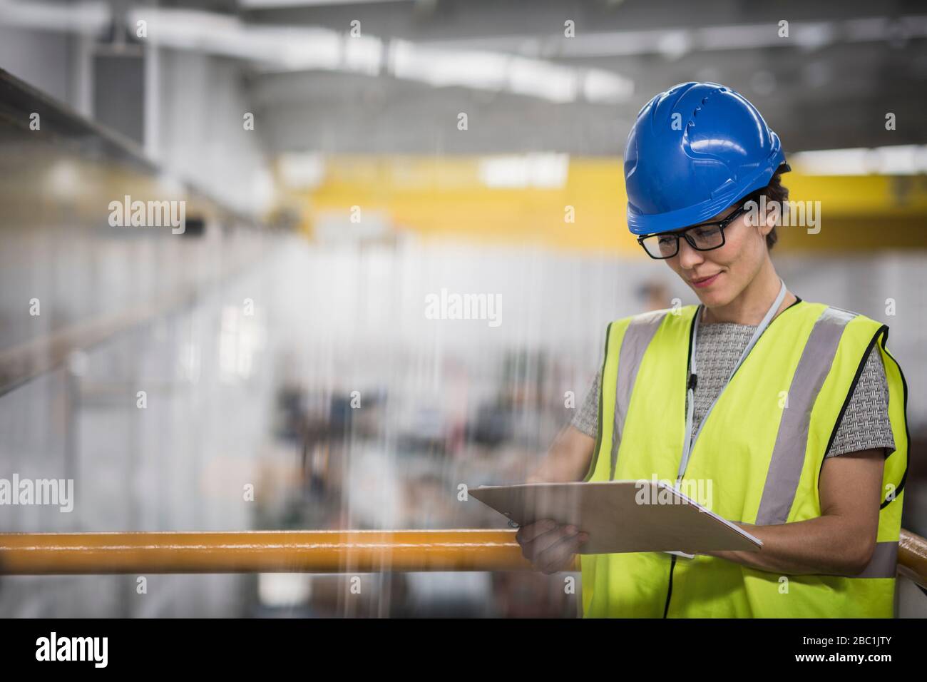 Superviseur femelle avec presse-papiers sur la plate-forme en usine Banque D'Images