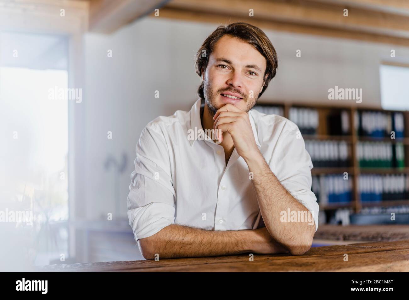Portrait d'un homme d'affaires confiant dans un bureau en bois à plan ouvert Banque D'Images