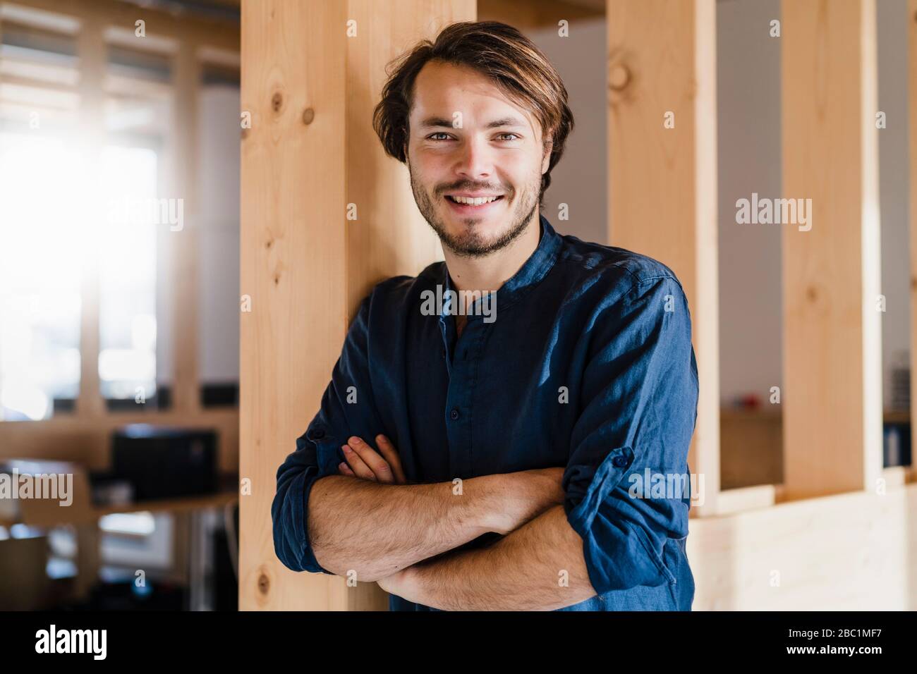 Portrait d'un homme d'affaires confiant dans un bureau en bois à plan ouvert Banque D'Images