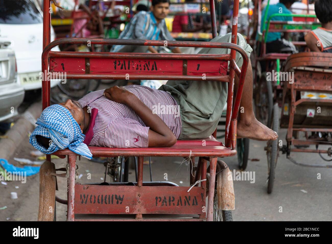 Chauffeur dormant sur son vélo pousse-pousse à Old Delhi, Inde Banque D'Images