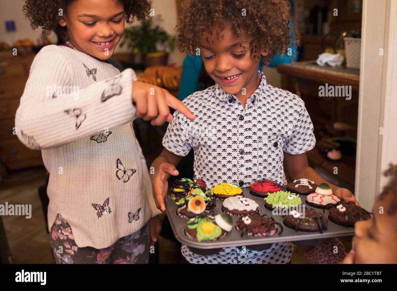 Joyeux frère et soeur avec des cupcakes d'Halloween décorés Banque D'Images
