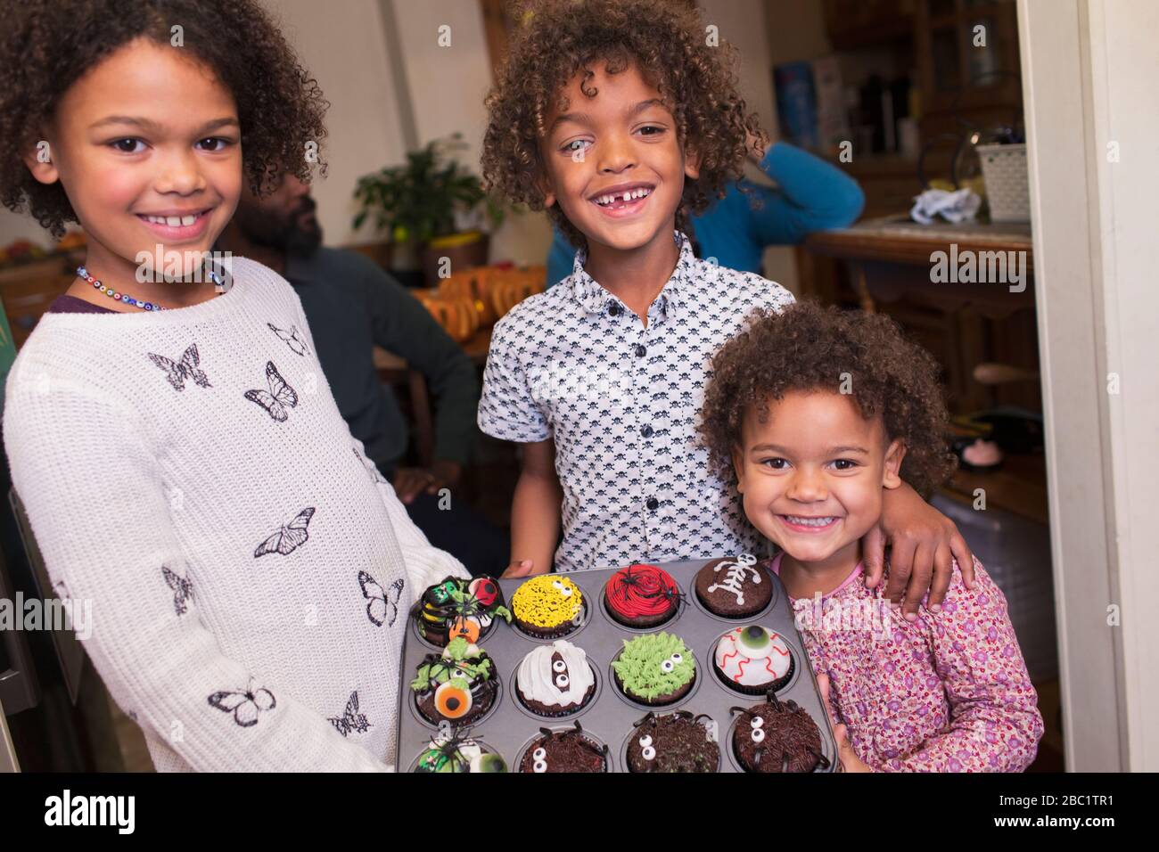 Portrait heureux frère et sœurs avec des cupcakes d'Halloween décorés Banque D'Images