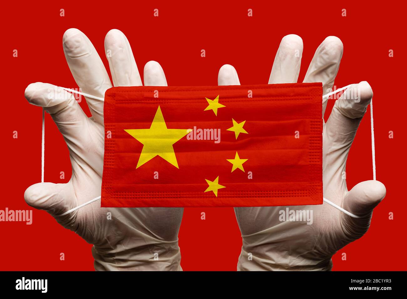 Médecin portant des gants blancs protection masque médical, bandage respiratoire avec drapeau national chinois superposé au masque. Concept Banque D'Images