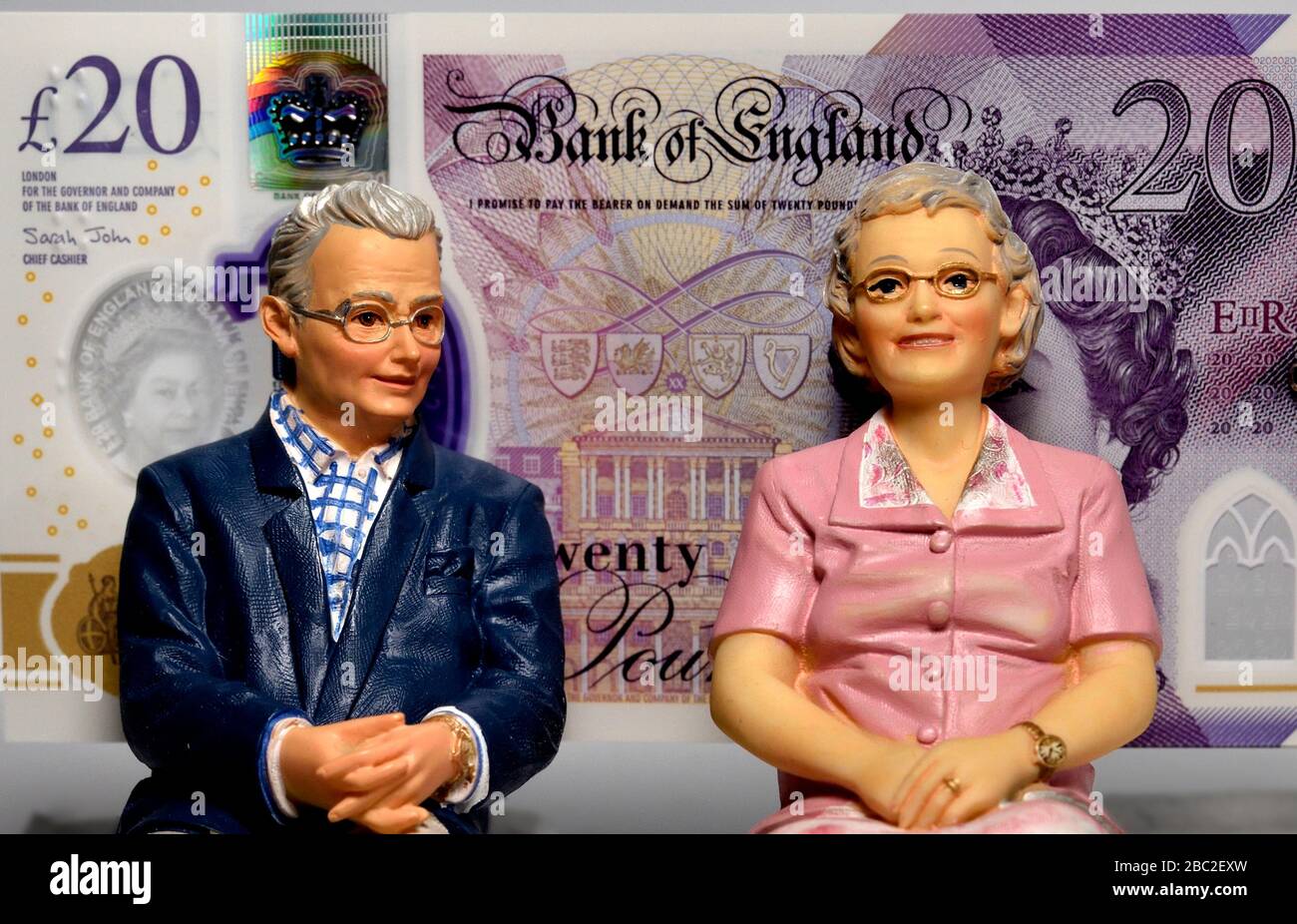 Couple retraité avec 20 livres de notes en arrière-plan. Banque D'Images