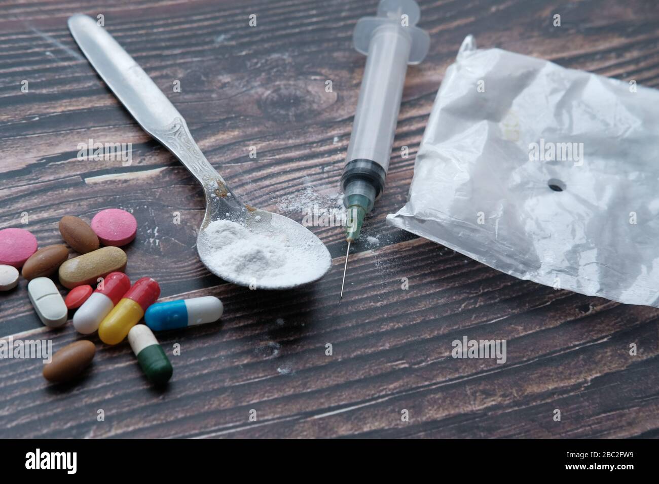 Seringue de drogue et héroïne cuite sur la cuillère, vue de dessus Banque D'Images