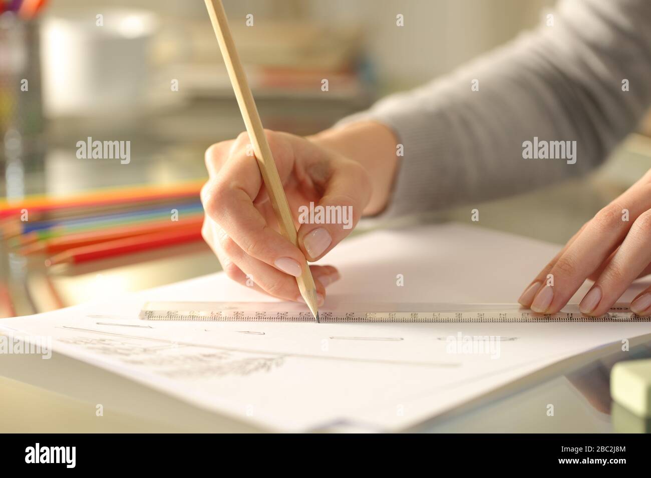 Gros plan des mains de la femme en ligne avec crayon et règle sur une feuille de papier sur un bureau à la maison Banque D'Images