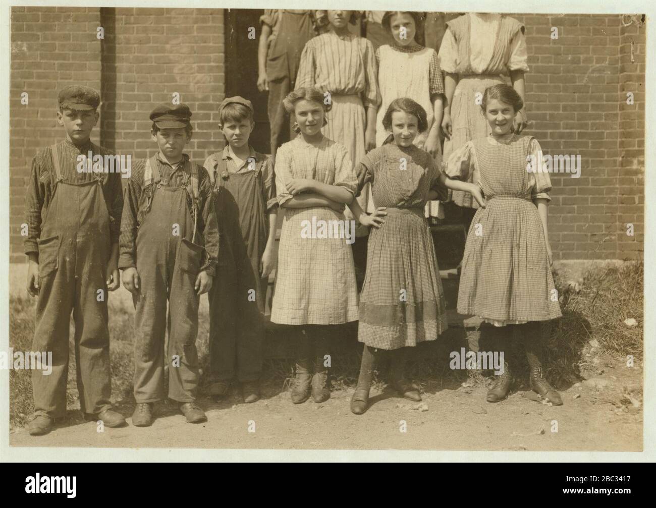 Groupe de travailleurs à Glenallen Mill, y compris Adrienne Pagnette, Annie Dugas, Francis Pagnette, Anatole Gernon, apparemment de 11 ou 12 ans, dégouts dans la salle de filature du dernier étage de ce qui précède Banque D'Images