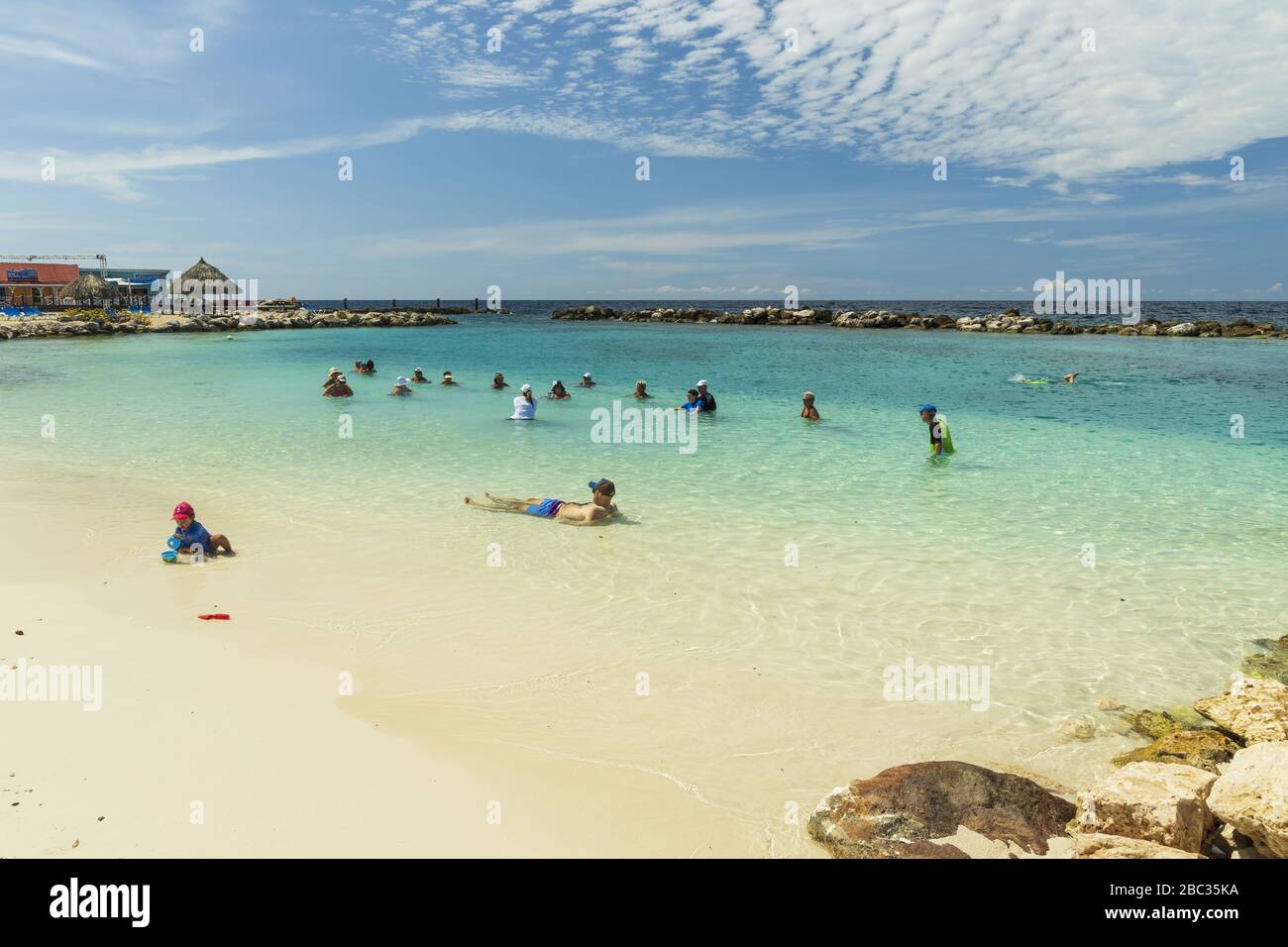 Touristes sur les exercices cardio-vasculaires. Plage de sable et océan Atlantique turquoise sur fond bleu ciel. Willemstad. Curaçao. Banque D'Images