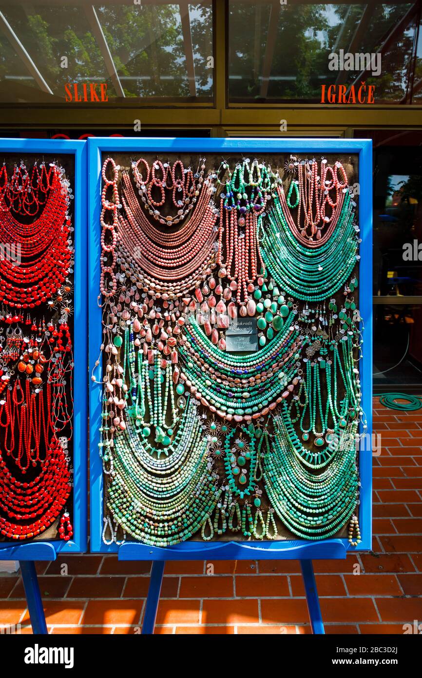 Affichage de cordes colorées de perles de jade vertes et roses et de colliers dans une boutique de souvenirs à Postojnska Jama (Parc de la grotte de Postojna), Slovénie Banque D'Images