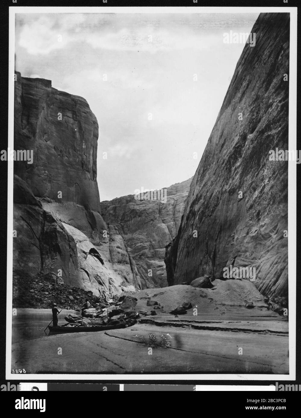 Le guidage d'un petit bateau à travers le détroit de la rivière Colorado à Lee's Ferry à Marble Canyon, Grand Canyon, 1900-1930 Banque D'Images
