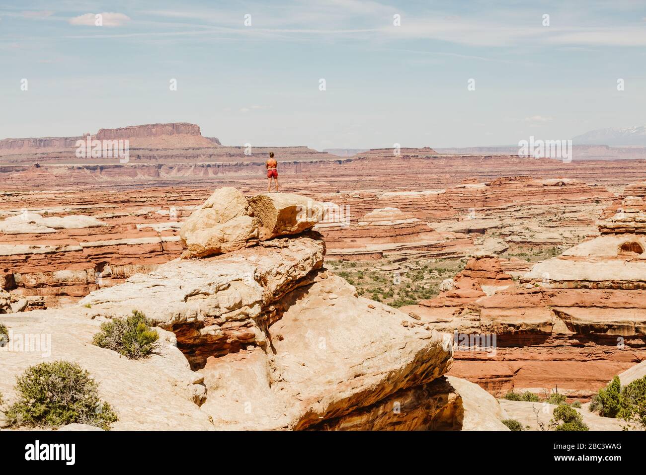 une femme de randonnée prend la vue sur une corniche surplombant le labyrinthe de l'utah Banque D'Images