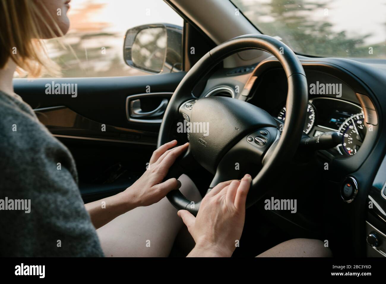 Vue intérieure d'une femme qui conduit à Big sur au coucher du soleil Banque D'Images