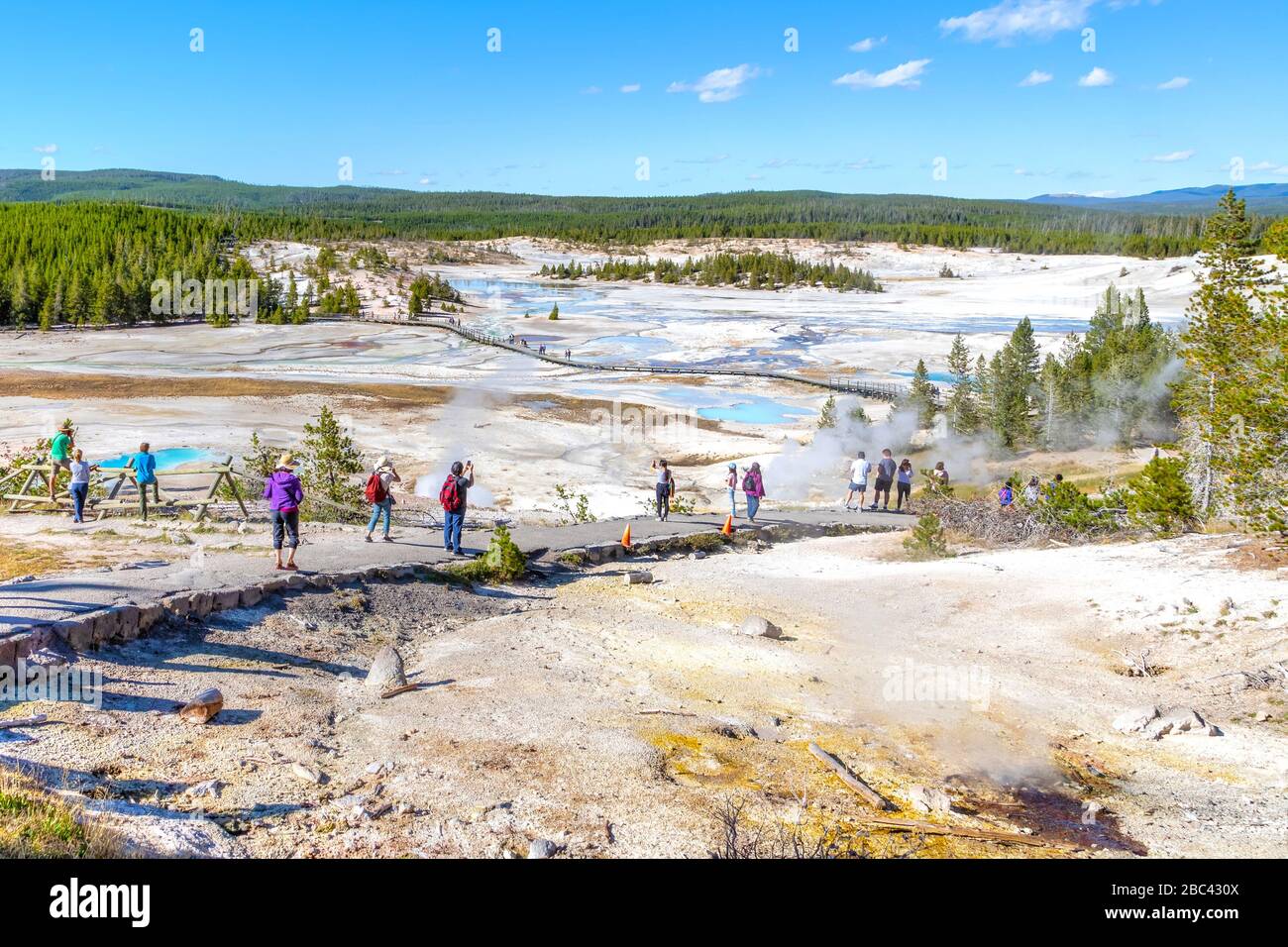 Visiteurs non reconnaissables marchant sur le sentier de promenade du bassin de la Porcelaine entouré de piscines géothermiques à l'intérieur du bassin de Norris Geyser de la nation Yellowstone Banque D'Images