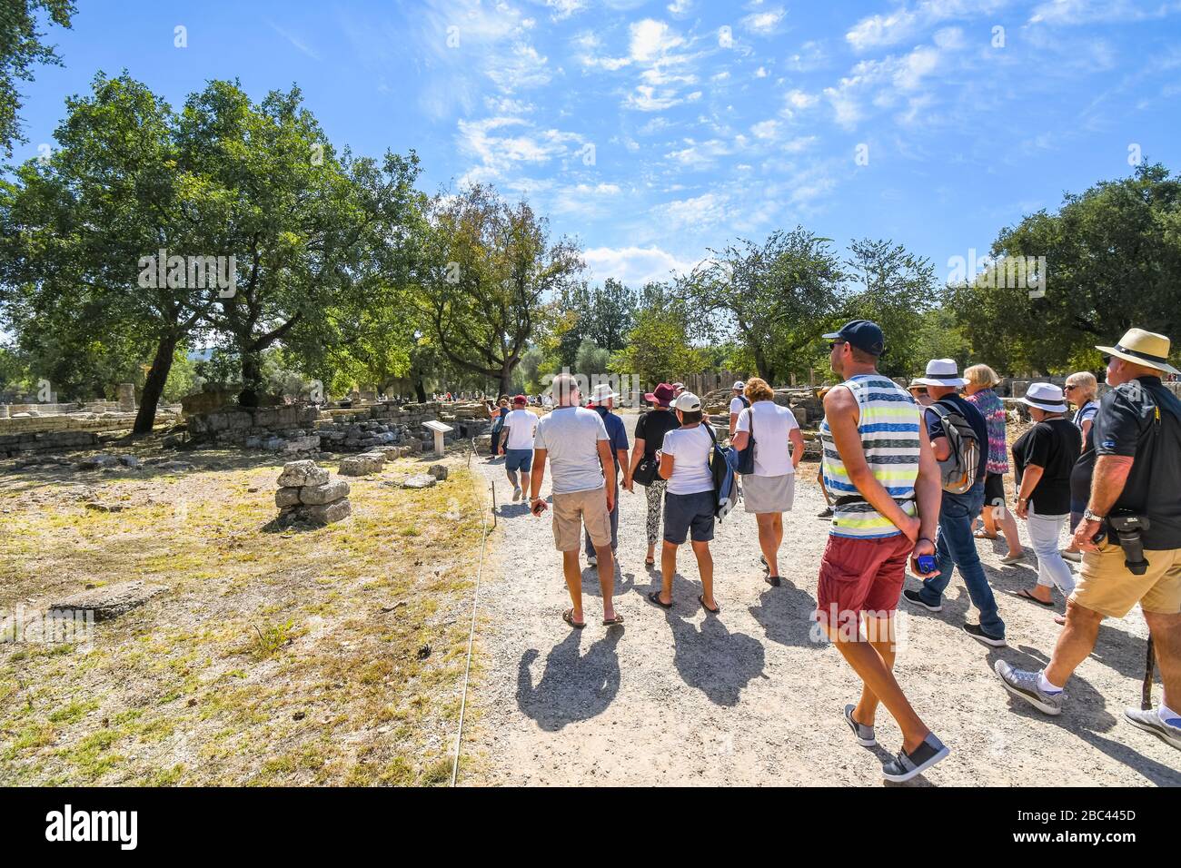 Un groupe de visites traverse les rues anciennes et le long des ruines grecques à Olympia, en Grèce. Banque D'Images