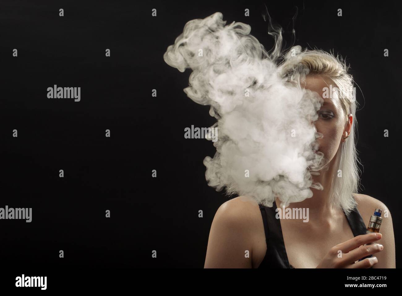 elfbar nachfüll pod läuft aus Jeune femme fumant cigarette électronique sur fond noir Photo Stock