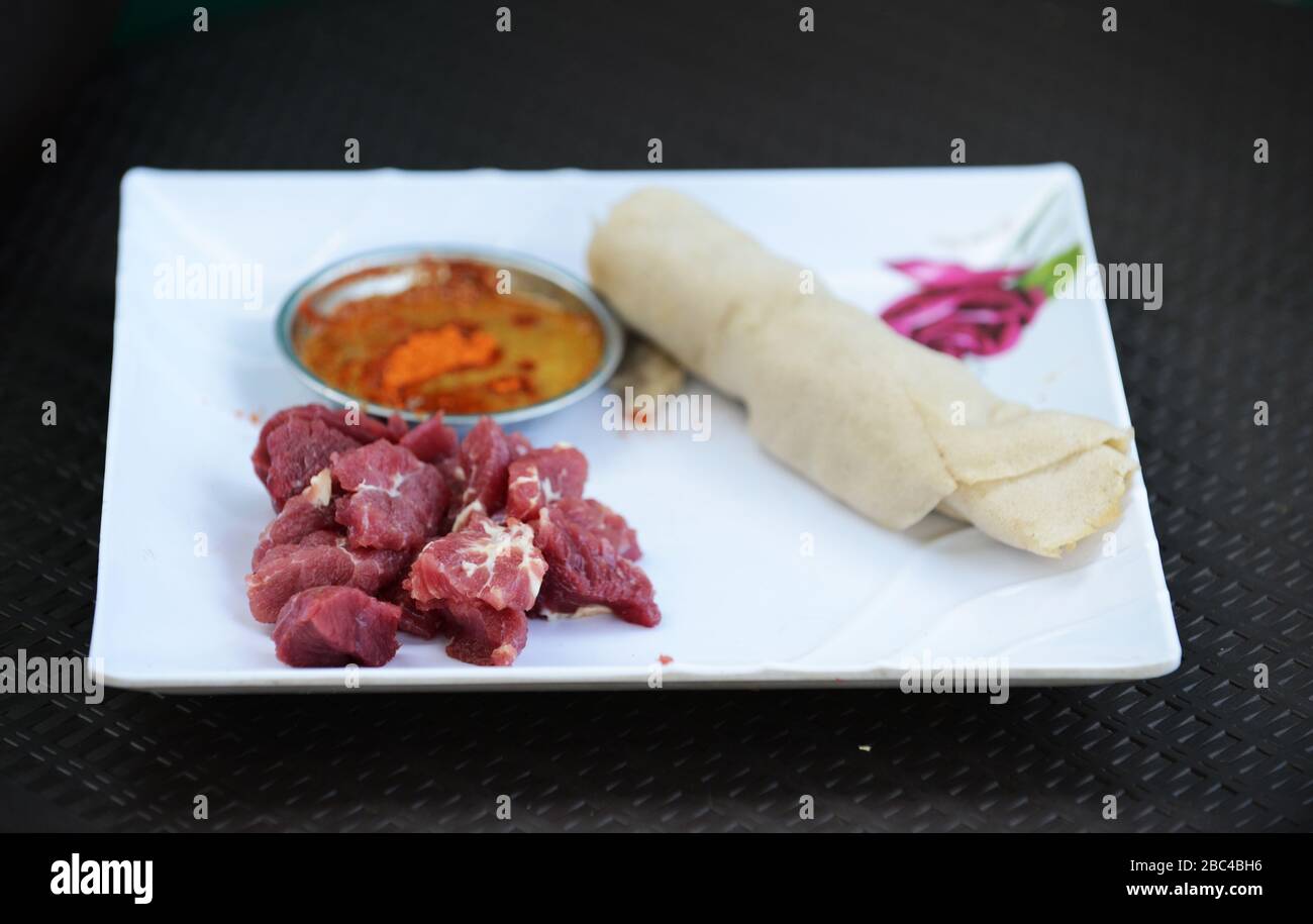 Un éthiopien mangeant Injera être pneu siga ( injera avec la viande brute ) Banque D'Images