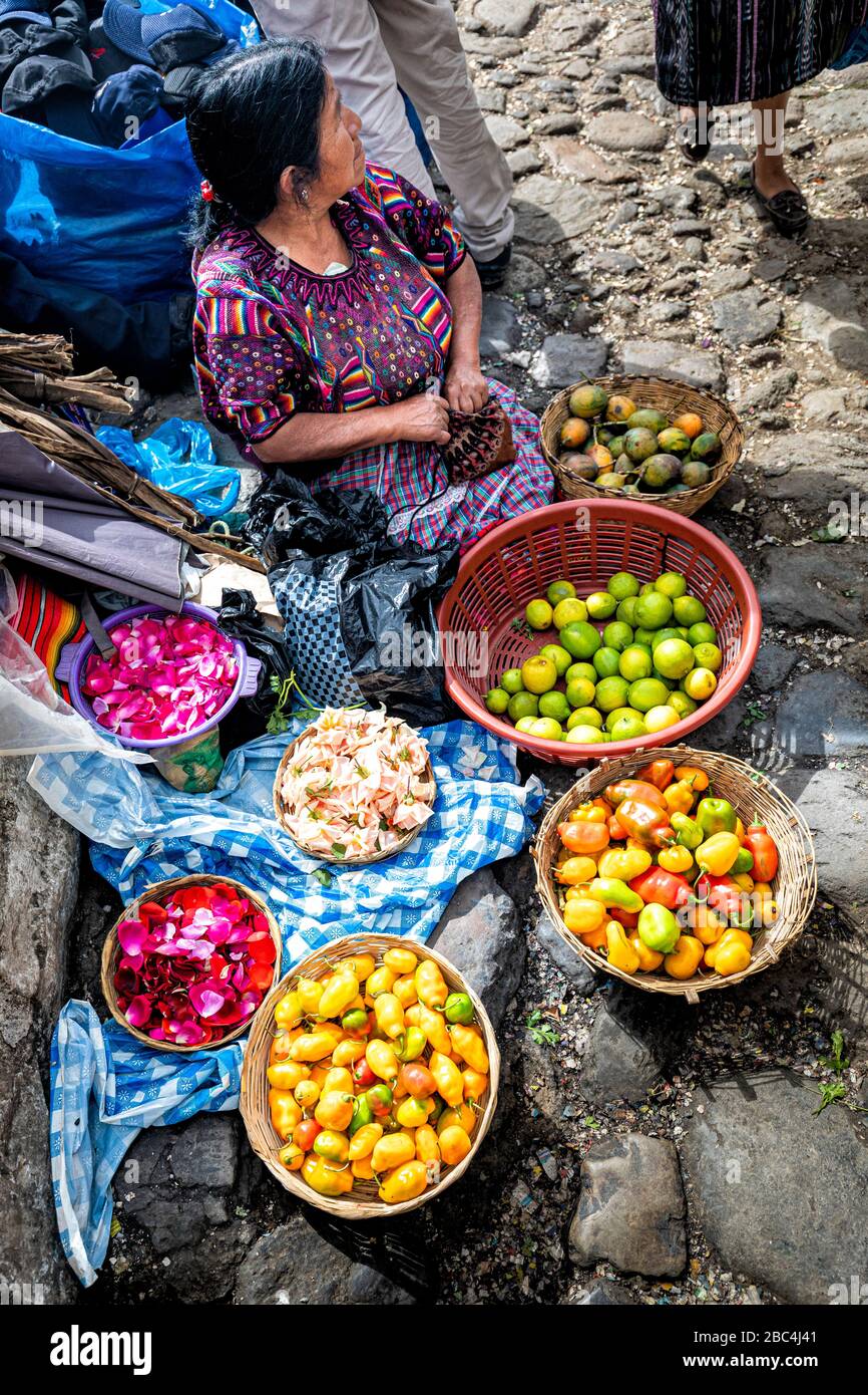 Une femme maya vend des pétales de fruits et de fleurs sur le marché de Chichicatenango, au Guatemala. Banque D'Images