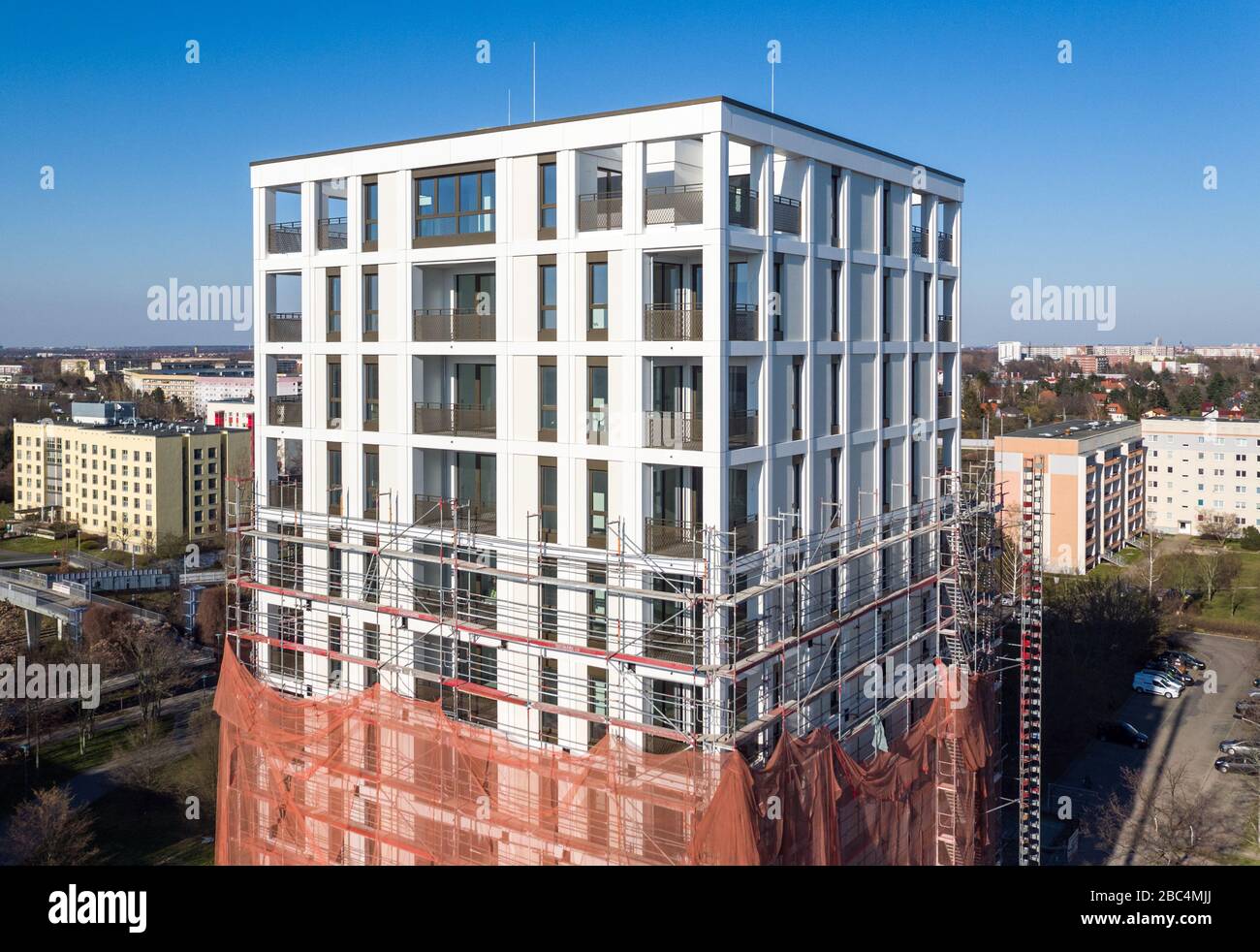 01 avril 2020, Saxe, Leipzig: Les échafaudages ont retiré les échafaudages du premier tiers de la nouvelle "Tour Lipsia". La première tour post-réunification dans le quartier de Granau, bâtiment en plaques de Leipzig, a une place pour 60 appartements sur ses 13 étages. La coopérative d'habitation Lipsia investit 13 millions d'euros. Le projet sans barrière 'Lipsia Tower' est principalement destiné aux locataires plus âgés. Selon les plans actuels, les premiers résidents devraient se déplacer en juillet. Les coopératives d'habitation saxonnes construisent 499 nouveaux appartements à l'échelle nationale en 2020. (Enregistré avec un drone) photo: J Banque D'Images