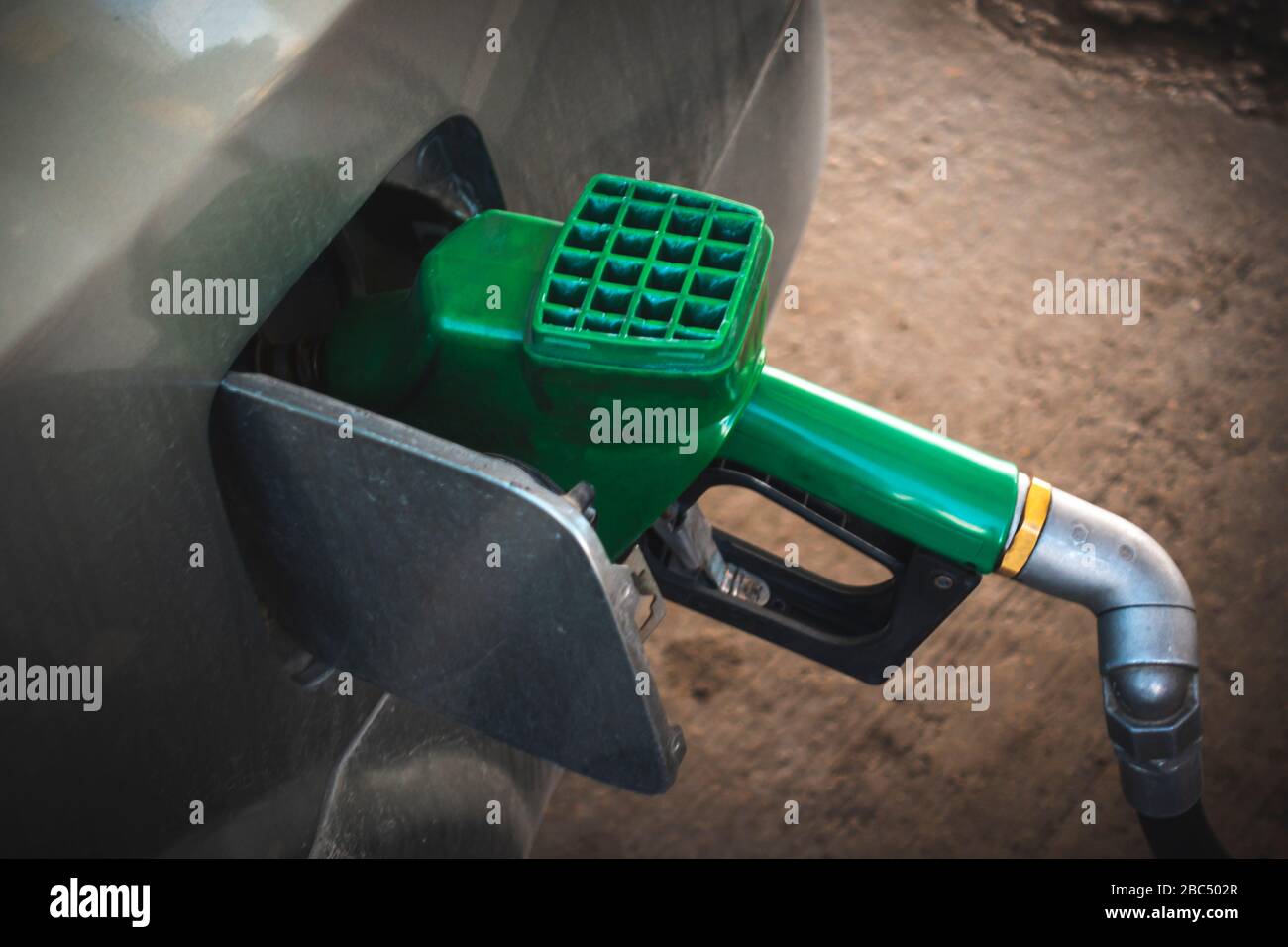 Distributeur de carburant vert remplissant le réservoir de carburant d'un véhicule Banque D'Images