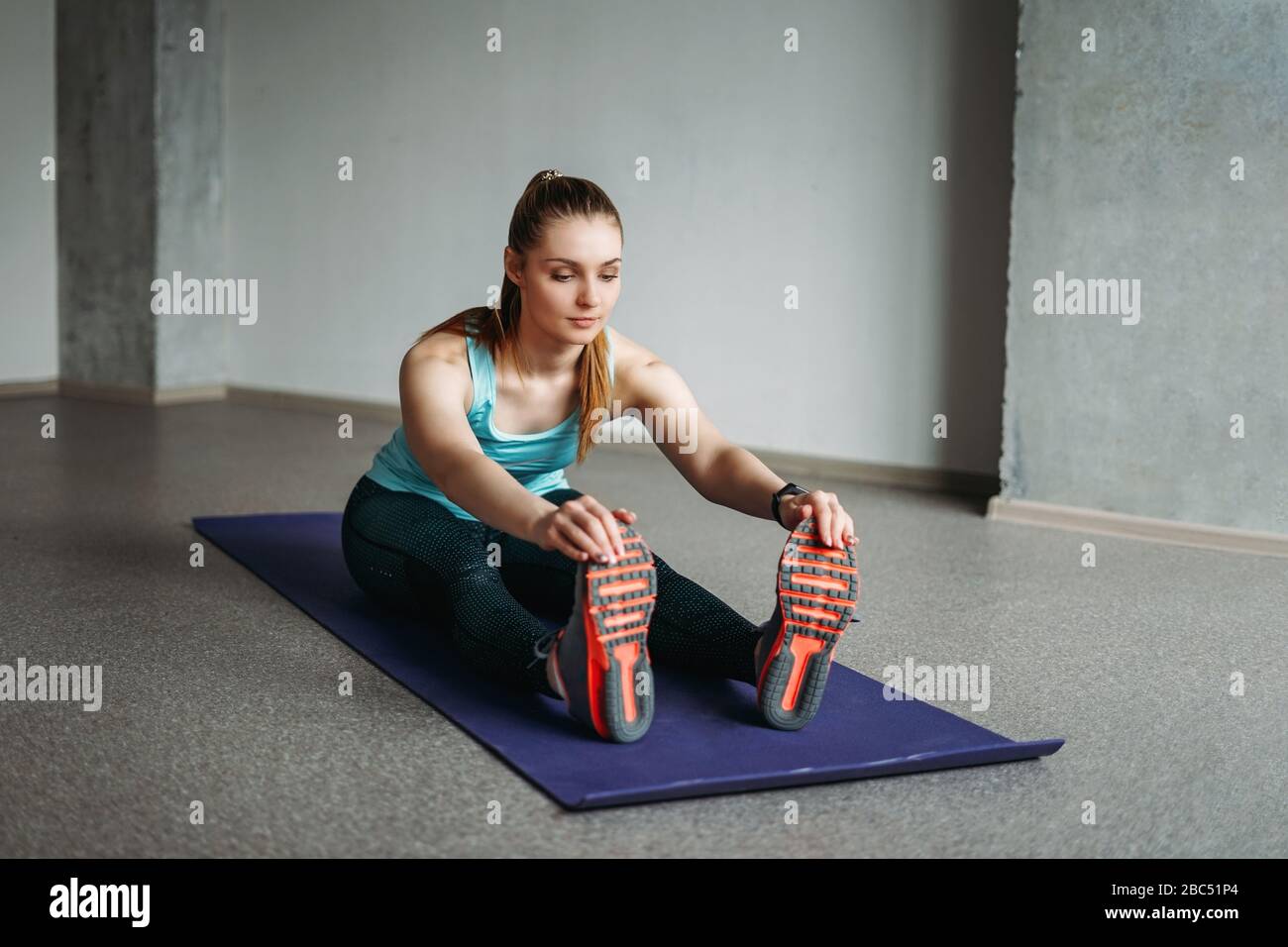 Belle tenue jeune femme sport porter une fille de forme physique s'étirant à la classe d'entraînement de studio à la maison Banque D'Images