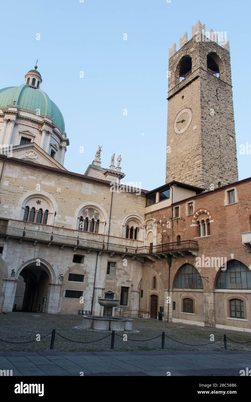 Brescia, Italie - 1 août 2018: La vue de la fontaine dans la cour intérieure du Palazzo del Broletto avec le nouveau dôme cathédrale et la Tour de galets sur l'arrière Banque D'Images