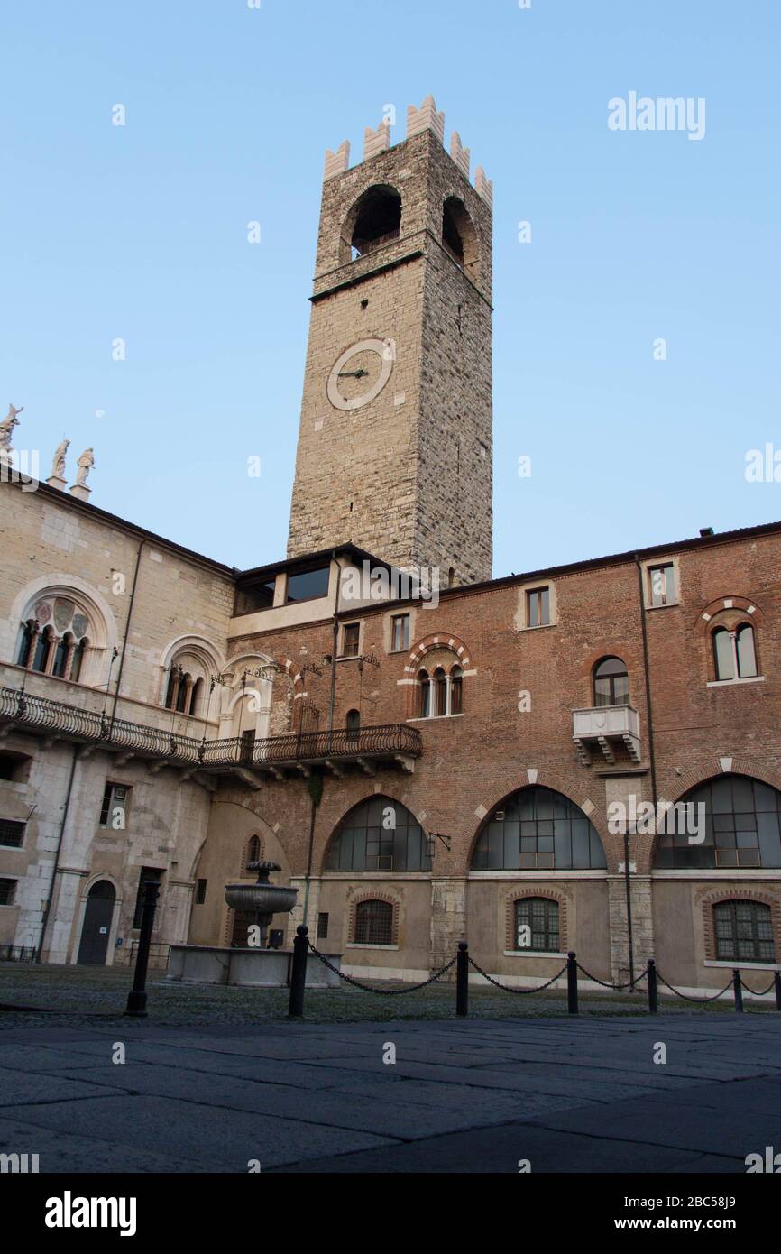 Brescia, Italie - 1 août 2018: La vue de la fontaine dans la cour intérieure du palais médiéval Palazzo del Broletto avec Tour de galets sur fond o Banque D'Images