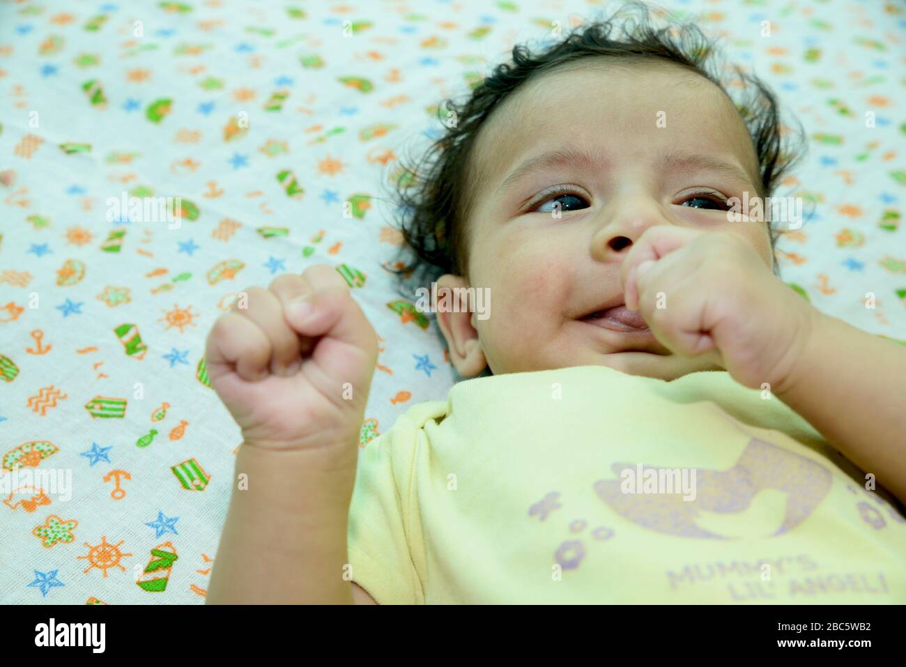 Bébé nouveau-né jouant sur le lit Banque D'Images