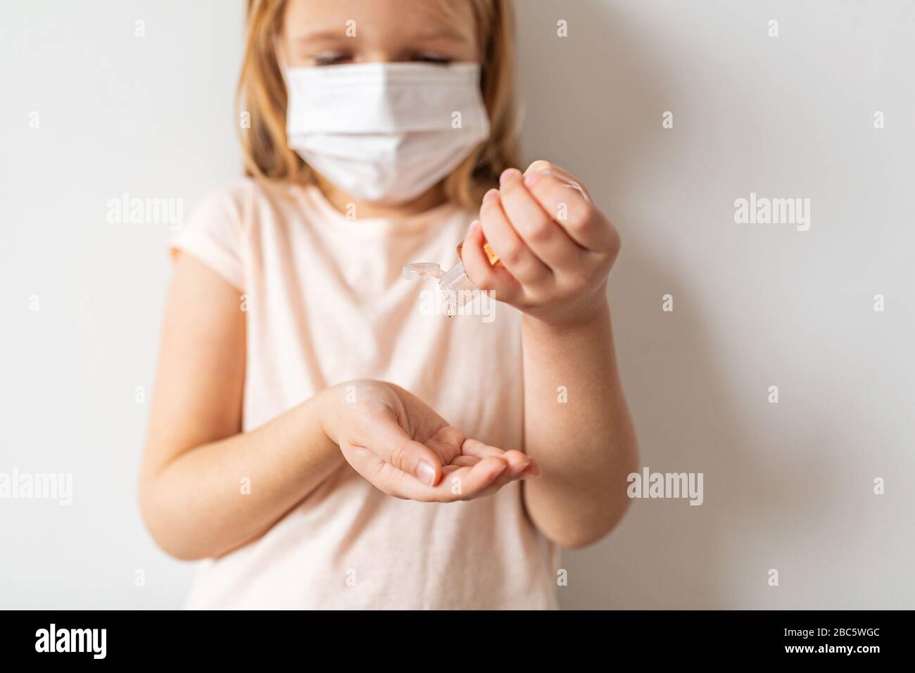 Petite fille caucasienne utilisant du gel d'alcool désinfectant pour les mains pour une hygiène des mains propre prévention de l'éclosion du virus du coronavirus. Garder les mains propres pendant Banque D'Images