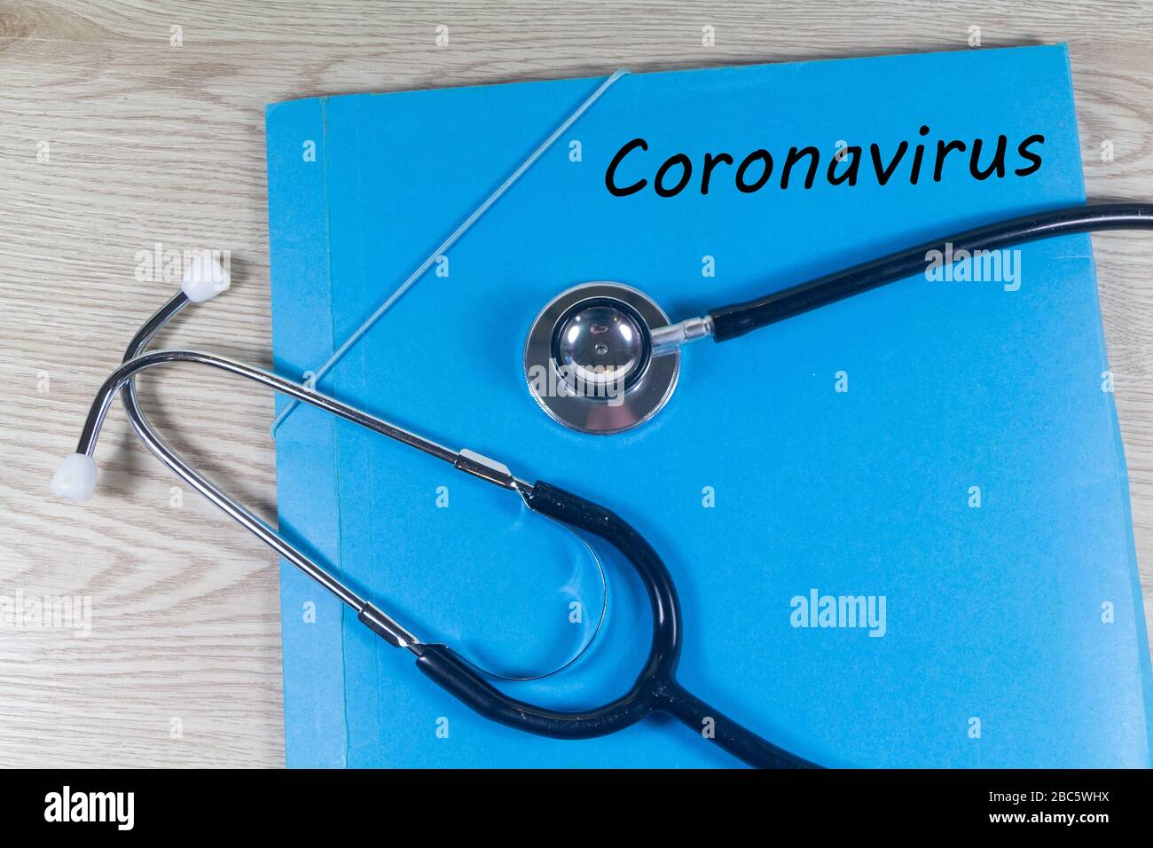 Coronavirus écrit sur un fichier bleu et stéthoscope noir Banque D'Images