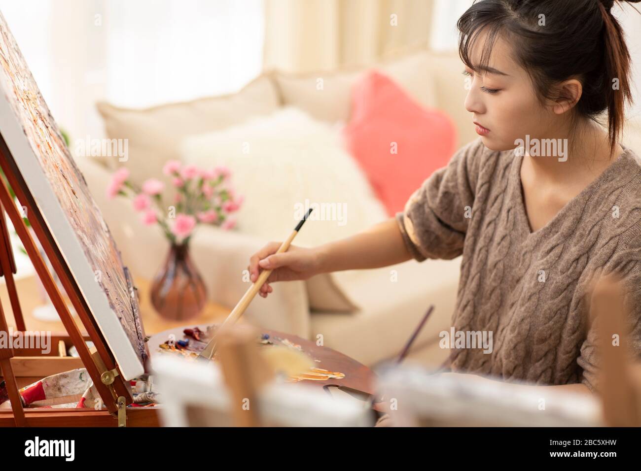 Jeune femme chinoise peint à la maison Banque D'Images