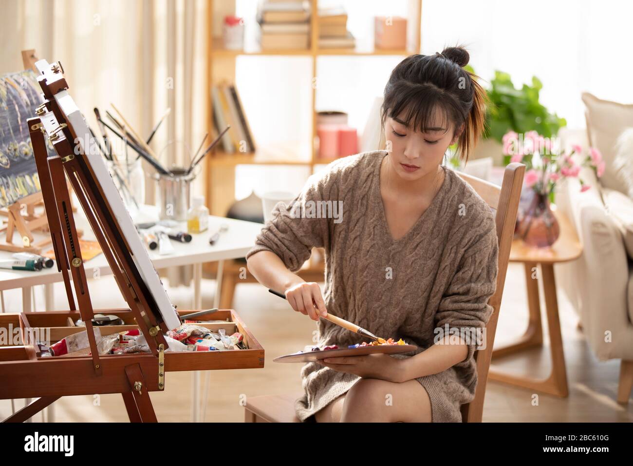 Jeune femme chinoise peint à la maison Banque D'Images