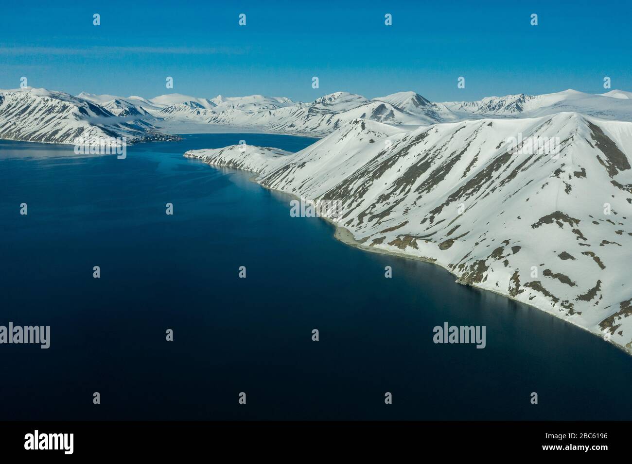 La côte montagneuse de la mer couverte de neige par un temps ensoleillé. Lieu de tournage sur la côte nord de la mer de Béring, région de Chukchi, Russie. Banque D'Images